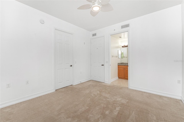 spare room with light colored carpet and ceiling fan