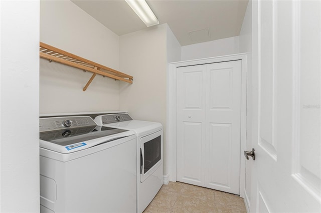 clothes washing area featuring light tile patterned floors and washing machine and clothes dryer