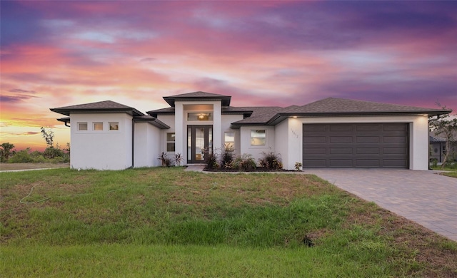 prairie-style home with a yard and a garage