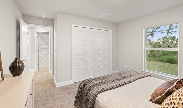 bedroom featuring light colored carpet and a closet