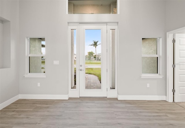 entryway with a high ceiling and light wood-type flooring