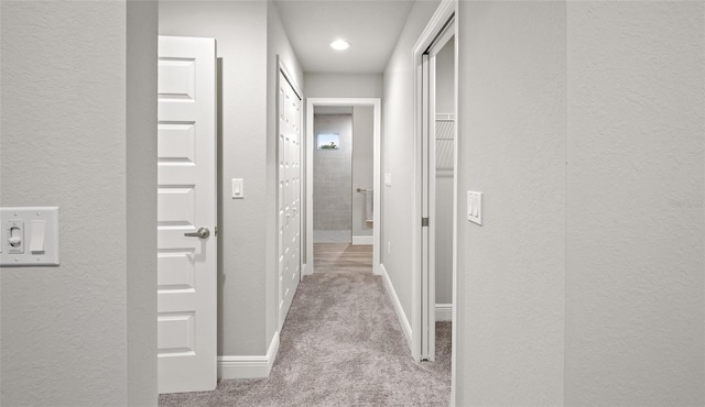 hallway featuring light colored carpet