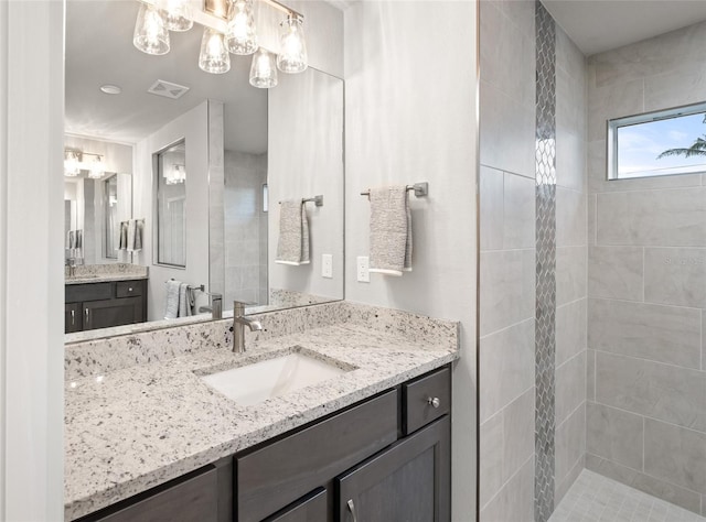 bathroom featuring vanity and a tile shower