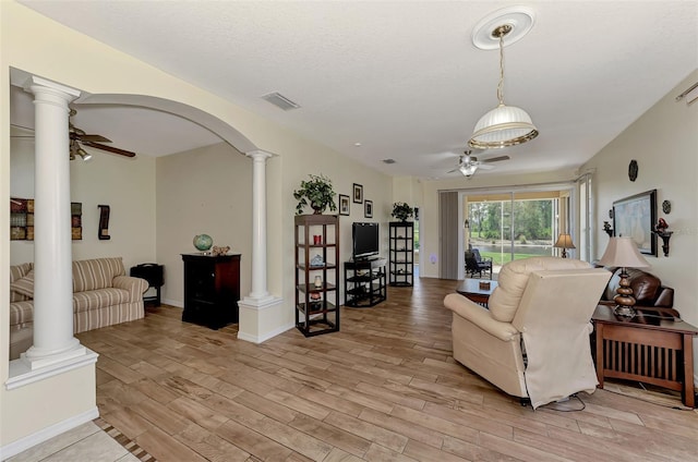 living room featuring ornate columns, a textured ceiling, ceiling fan, and light hardwood / wood-style flooring