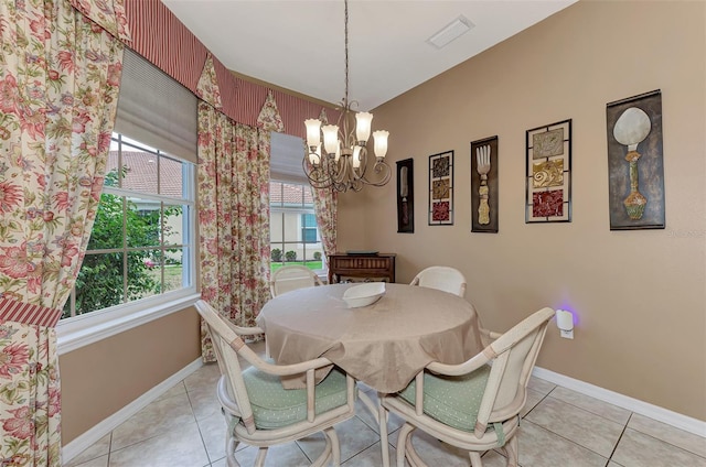 dining space featuring light tile patterned flooring and a chandelier