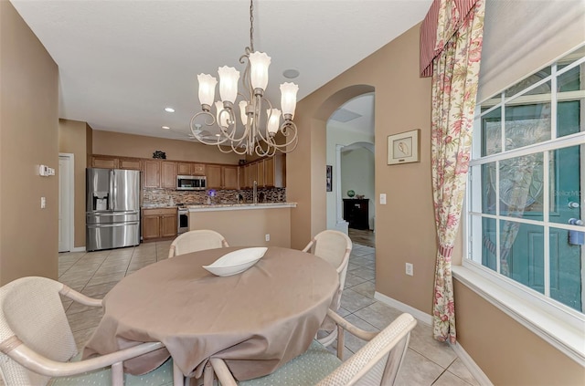 tiled dining space featuring a notable chandelier