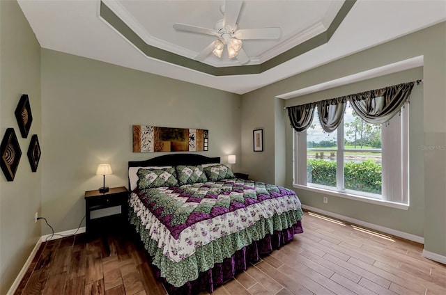 bedroom featuring ornamental molding, ceiling fan, and a tray ceiling