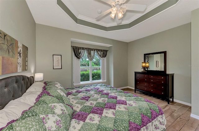 bedroom featuring crown molding, a tray ceiling, and ceiling fan