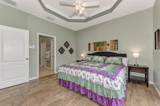 bedroom with a raised ceiling, crown molding, and ceiling fan