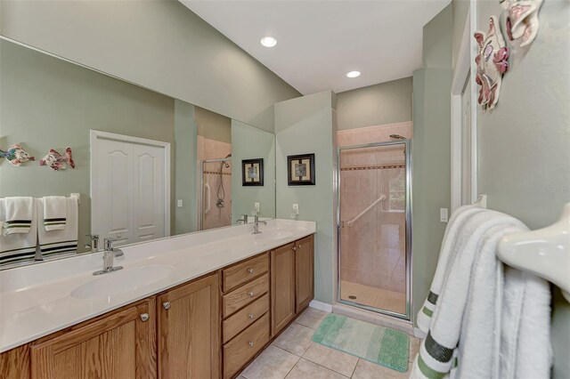 bathroom with a shower with door, vanity, and tile patterned floors