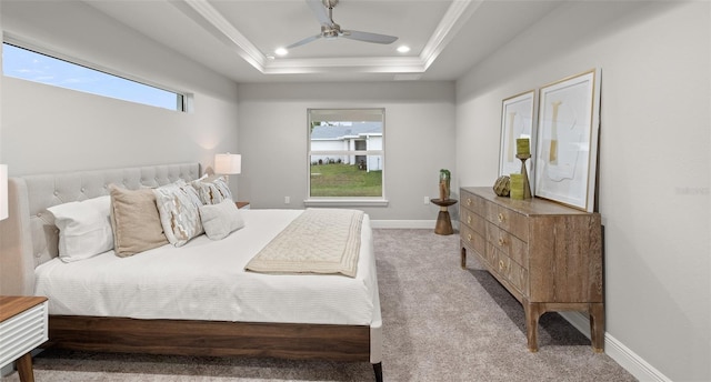 carpeted bedroom with crown molding, ceiling fan, and a raised ceiling