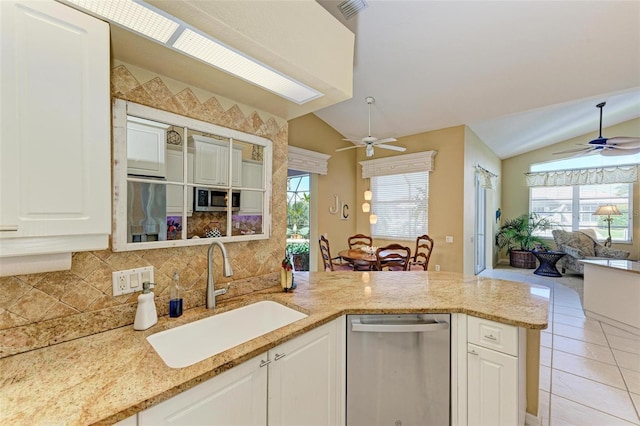 kitchen with stainless steel appliances, vaulted ceiling, white cabinetry, and sink