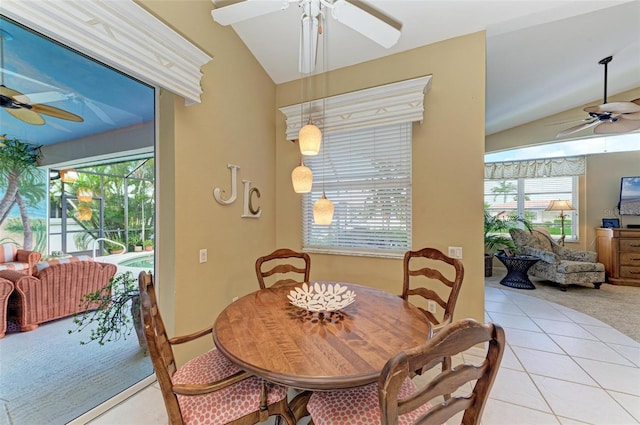 dining area featuring a wealth of natural light, light tile patterned floors, and vaulted ceiling