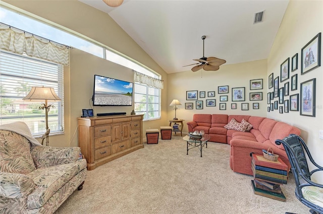 living room featuring a wealth of natural light, ceiling fan, light colored carpet, and lofted ceiling