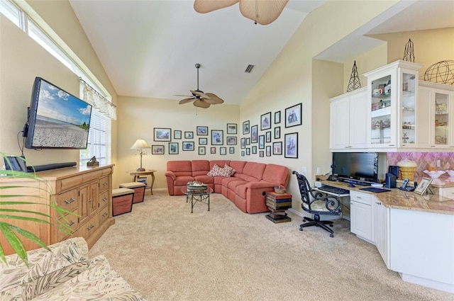 carpeted office featuring ceiling fan, built in desk, and vaulted ceiling