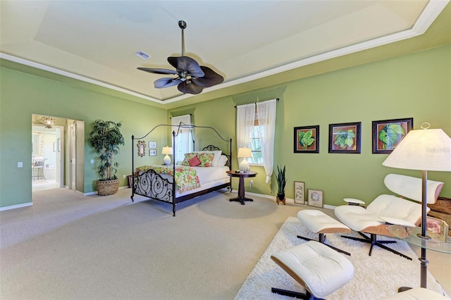 carpeted bedroom with connected bathroom, a tray ceiling, and ceiling fan