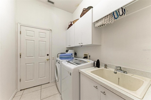 clothes washing area with cabinets, light tile patterned floors, separate washer and dryer, and sink