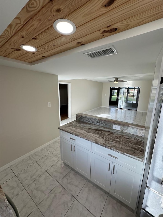 kitchen featuring ceiling fan, white cabinetry, and wood ceiling