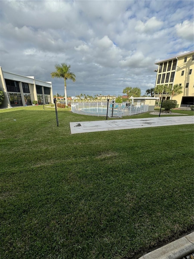 view of home's community featuring a lawn and a swimming pool