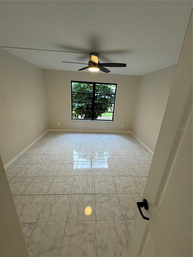 spare room featuring ceiling fan and a textured ceiling