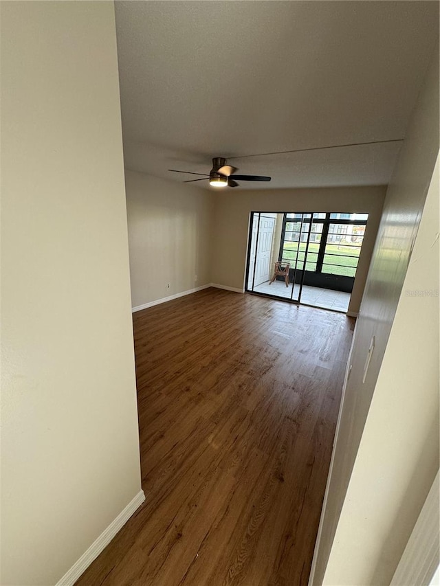 unfurnished room with ceiling fan and wood-type flooring