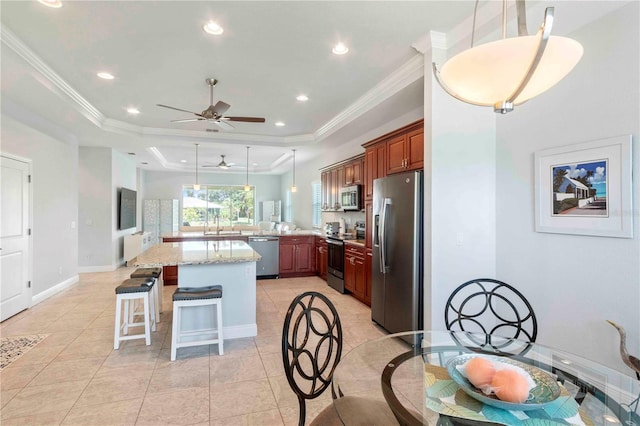 kitchen featuring kitchen peninsula, appliances with stainless steel finishes, decorative light fixtures, and crown molding