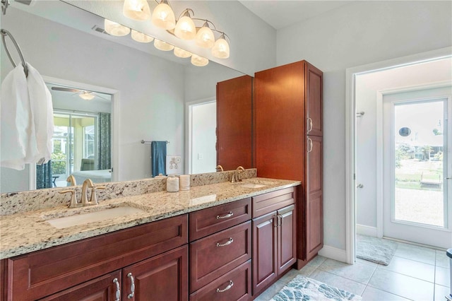 bathroom with tile patterned flooring, vanity, and a healthy amount of sunlight