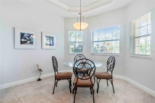 dining room with light tile patterned floors, a raised ceiling, a wealth of natural light, and ornamental molding