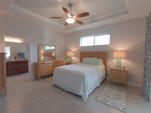 tiled bedroom with a raised ceiling, ensuite bath, and ceiling fan