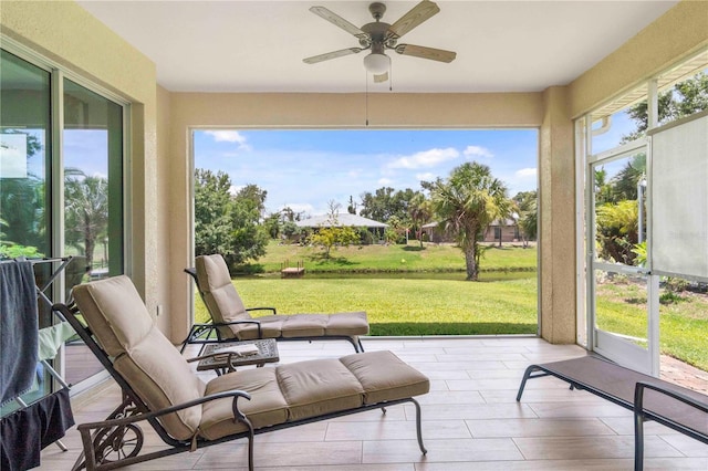 sunroom featuring ceiling fan and a wealth of natural light