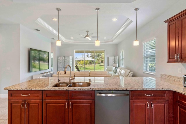 kitchen featuring ceiling fan, sink, a raised ceiling, stainless steel dishwasher, and pendant lighting