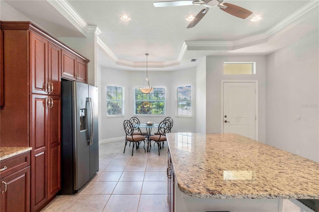 kitchen featuring ceiling fan, a center island, a raised ceiling, stainless steel fridge with ice dispenser, and ornamental molding