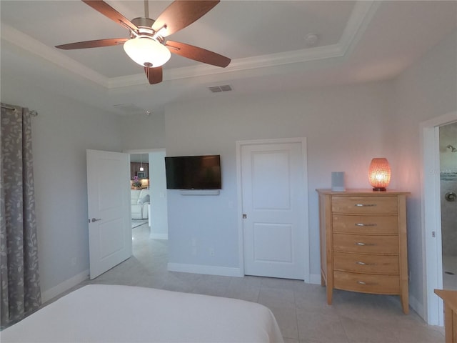 bedroom with ceiling fan, light tile patterned floors, and a tray ceiling