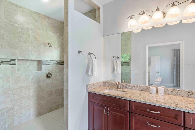 bathroom featuring a tile shower and vanity