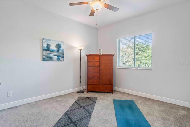 interior space with ceiling fan and light colored carpet