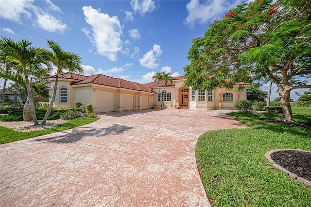 mediterranean / spanish-style house featuring a front yard and a garage