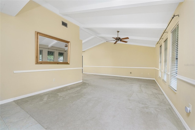 carpeted spare room with vaulted ceiling with beams, ceiling fan, and a healthy amount of sunlight