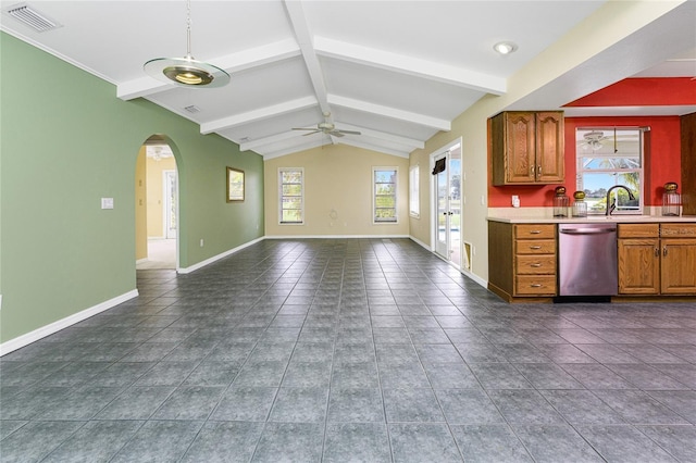 kitchen featuring sink, stainless steel dishwasher, ceiling fan, vaulted ceiling with beams, and dark tile patterned floors