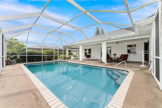 view of swimming pool featuring glass enclosure, ceiling fan, and a patio