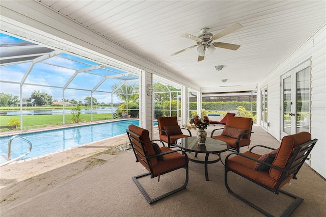 view of pool with french doors, a lanai, an outdoor hangout area, a water view, and a patio