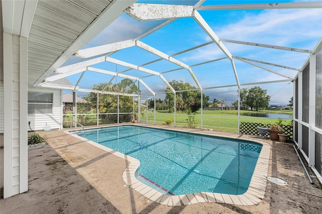 view of pool with a lawn, glass enclosure, a water view, and a patio