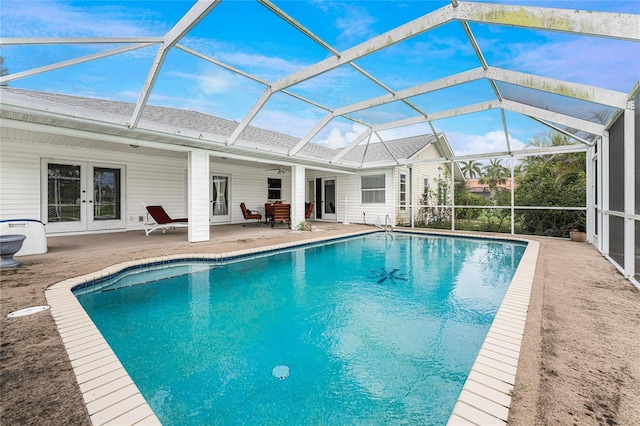 view of swimming pool featuring french doors, a patio, glass enclosure, and ceiling fan