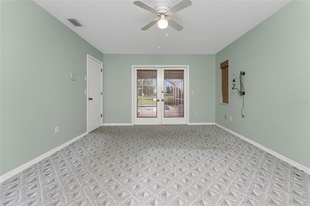 empty room featuring ceiling fan and french doors