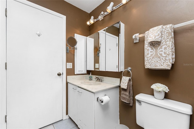 bathroom with tile patterned flooring, vanity, and toilet