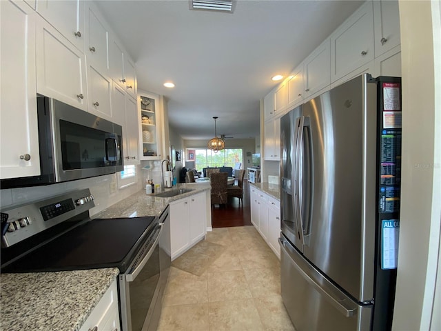 kitchen featuring white cabinets, appliances with stainless steel finishes, sink, and backsplash