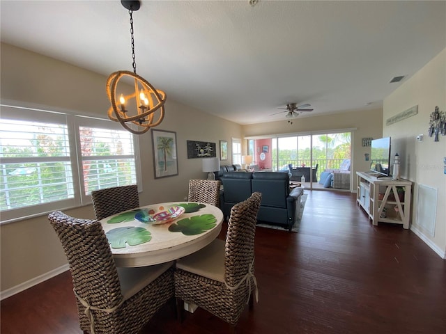 dining space with dark hardwood / wood-style flooring and ceiling fan with notable chandelier