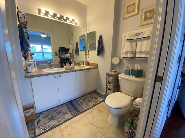 bathroom with double vanity, tile flooring, and toilet