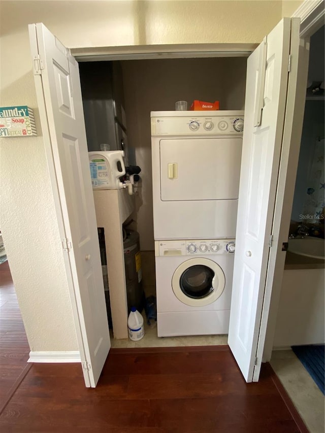 washroom with stacked washer and clothes dryer and hardwood / wood-style floors