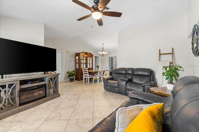 living room with ceiling fan with notable chandelier, light tile patterned floors, and vaulted ceiling