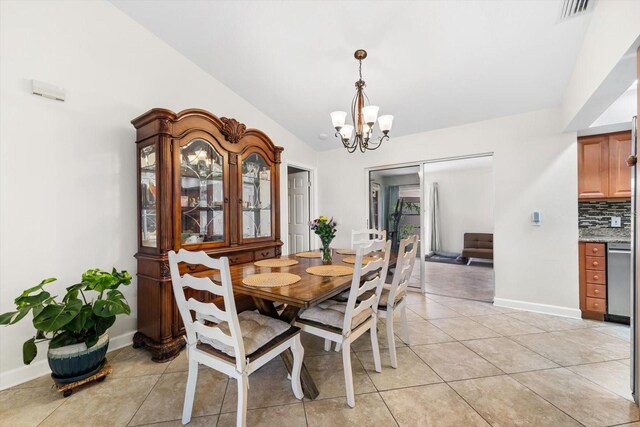 dining room featuring light tile patterned flooring, vaulted ceiling, and a notable chandelier